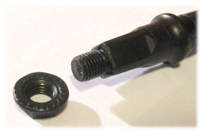 End of nut-type spindle. The serrated face of the nut presses against the crank.